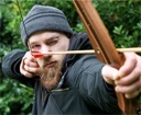 archer shooting a traditional hunter recurve archery bow hunger games style